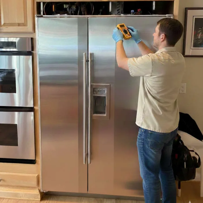 Technician repairing Sub-Zero refrigerator